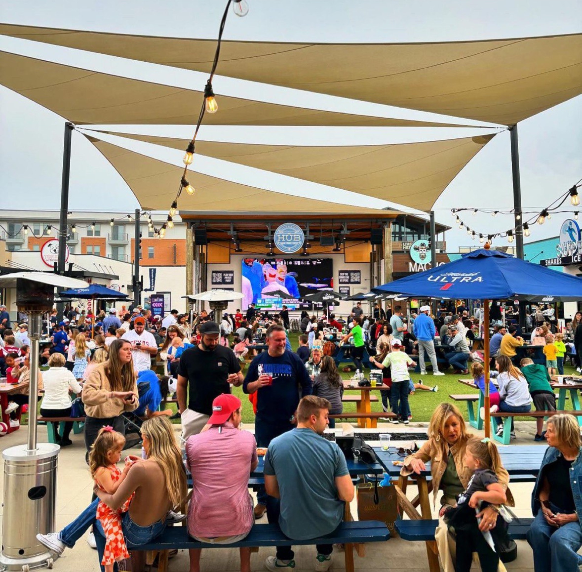 Packed courtyard at The HUB with Jumbotron showing match