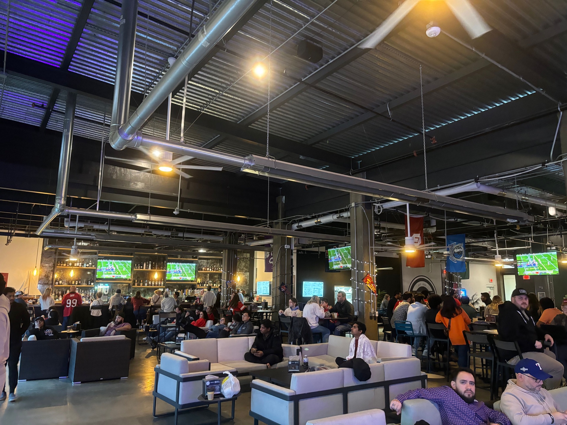 Indoor sports bar packed with fans watching on big screens